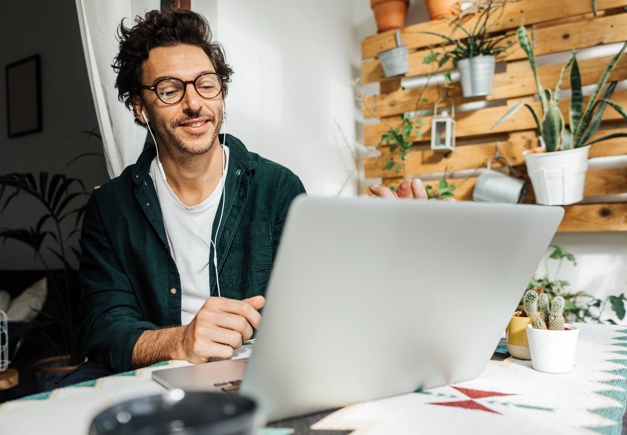 Man with laptop working remotely from home. Freelancer at remote work. Cosy workplace